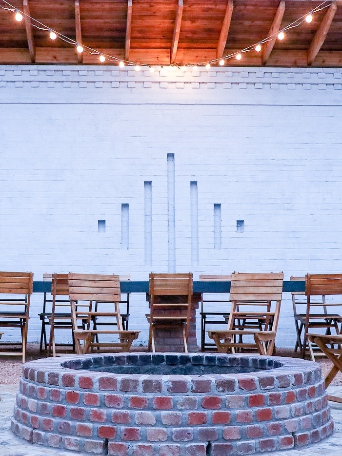 A courtyard gathering space with a long communal table and string lights overhead